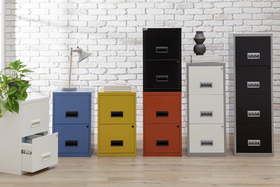 A collection of white, blue, yellow, red and black filing cabinets displayed in front of a white wall. 