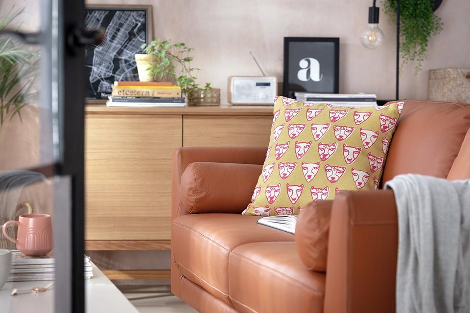 Image of mustard cushion on tan sofa.