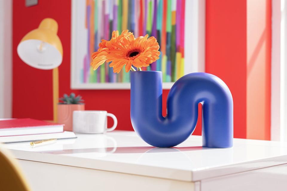 Image of blue vase with flower on whitedesk.