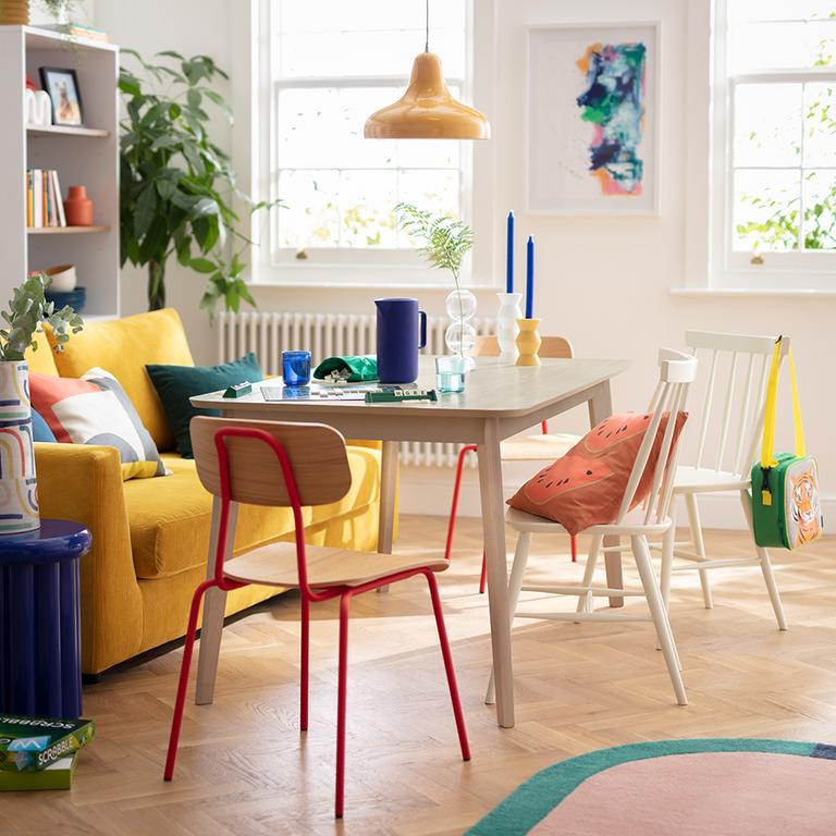 Colourful living room with dining set and yellow sofa.