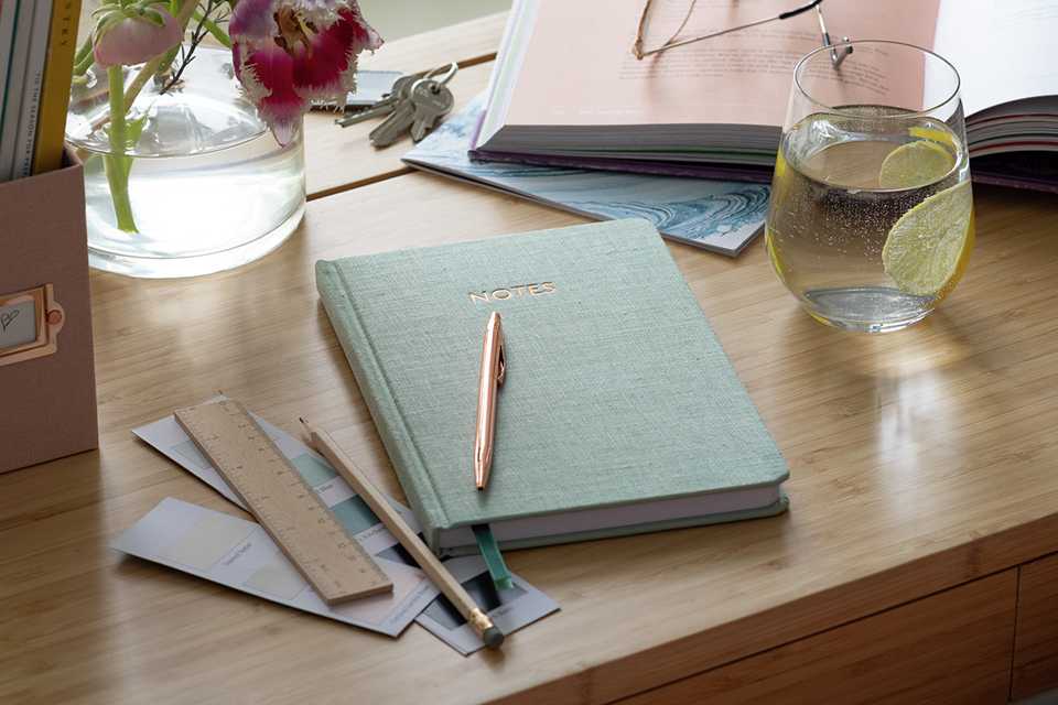 Desk with note books and pens.