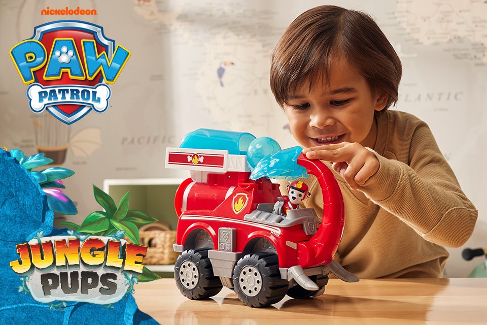 A kid playing with PAW Patrol Jungle Pups toy vehicle.