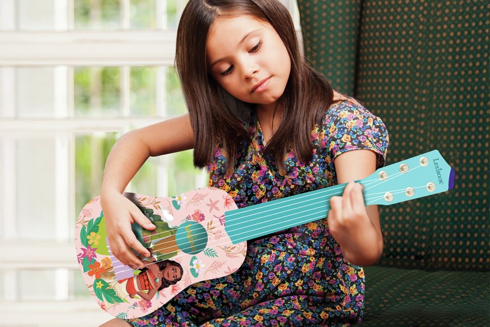 A girl playing a Disney Moana My 1st Guitar.