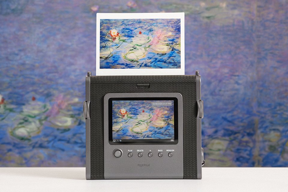 A instax™ WIDE Evo hybrid camera printing a picture of Monet's flowers.