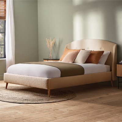 Green bedroom with cream boucle bed in bedroom.