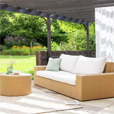 Garden chairs with white cushions in garden.