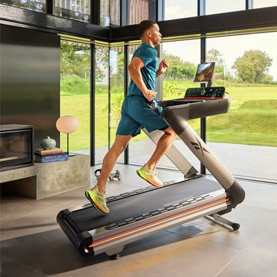 A man using Reebok Z-Tech DC Treadmill with Connected Fitness.