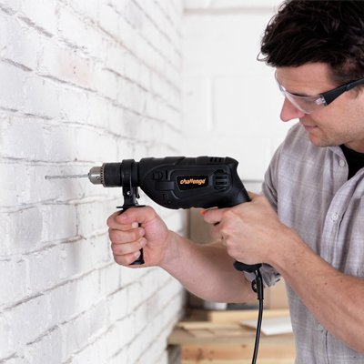 Man drilling wood in garage.