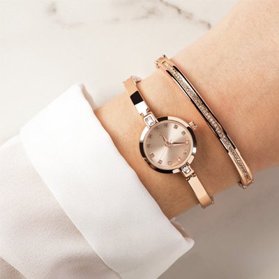 A woman wearing a Spirit stone watch and bracelet in rose colour.