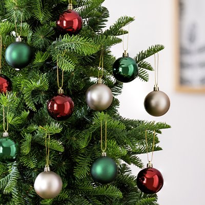 A tree dressed with red, green, and silver Christmas baubles.