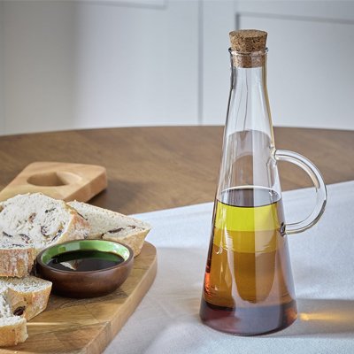 Kitchen counter with oil bottle and bread board.