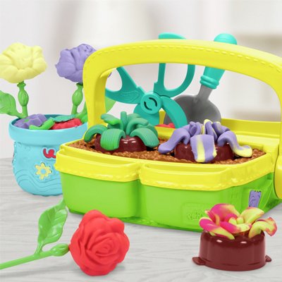 A little girl playing with Play-Doh Blooming Flowers with 5 Tubs & 15 Accessories.