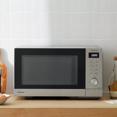 Panasonic 1000W Standard Microwave NN-SD37QSBPQ in grey colour placed on a wooden counter. 
