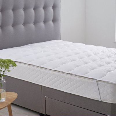 Mattress topper on mattress in bedroom.