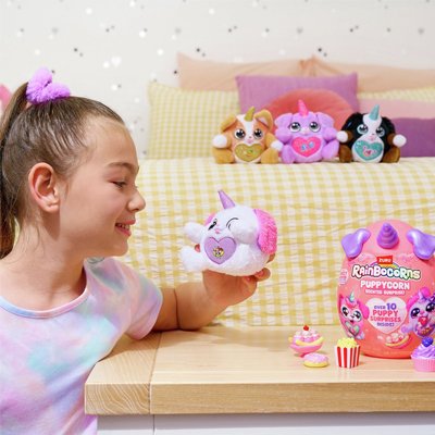 A child with an armful of ZURU Rainbocorns Sparkle Heart Surprise Series 3 Puppycorns.
