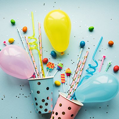 Balloons, candies, straws and paper cups in different colours.