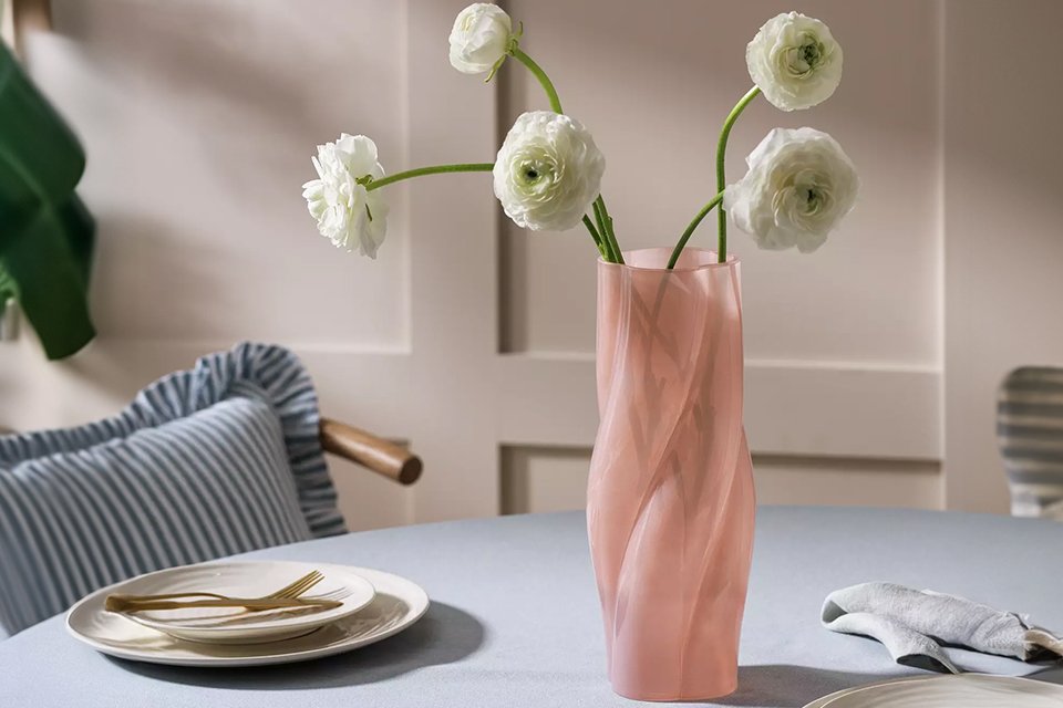 Pink spiral vase with flowers on dining room table, perfect for gifting your special someone.