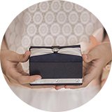 A woman in a wedding gown holding a gift box.