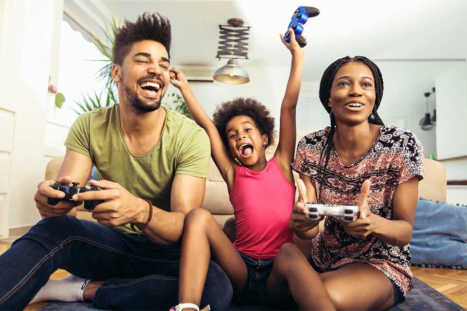 A family of 3 playing a video game together. 