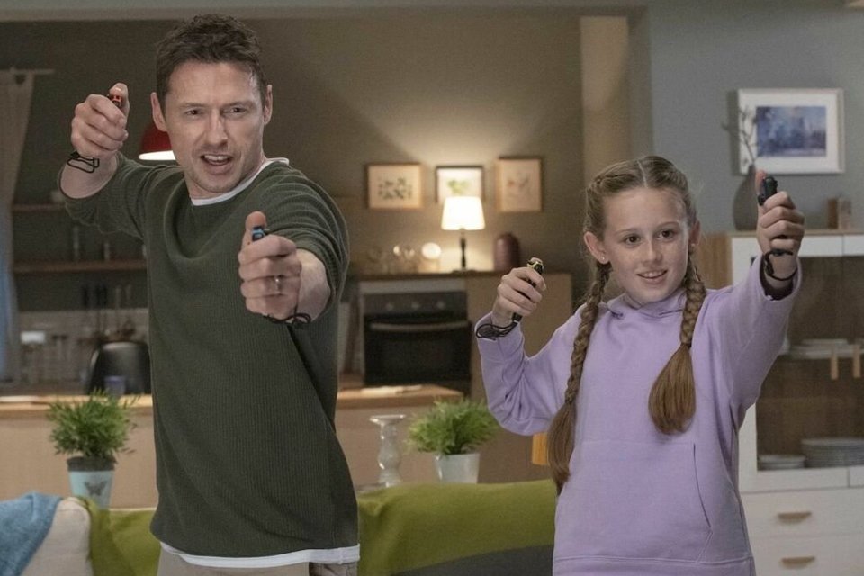 Father and daughter playing console game.