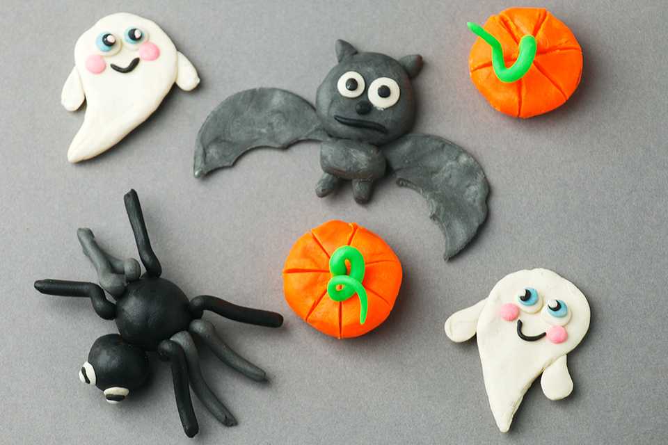 An assortment of Halloween spiders, bats, ghosts and pumpkins made from modelling clay.