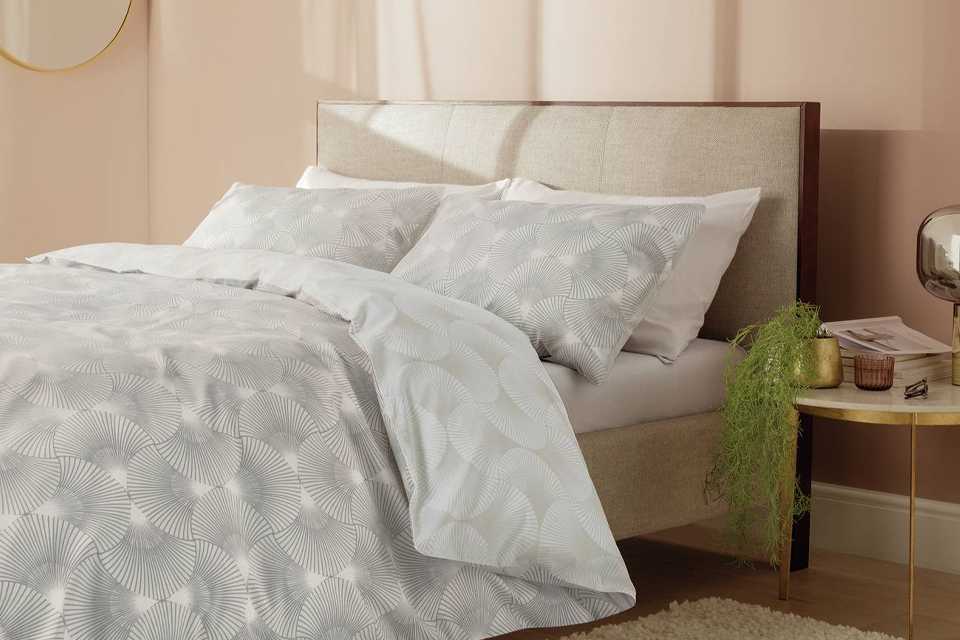 Image of a guest bedroom with a patterned pillow and duvet set.