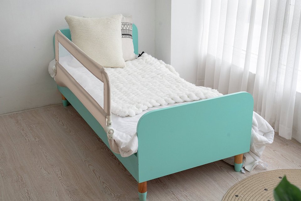 A Cuggl Bed Rail in grey fitted on a child's bed.