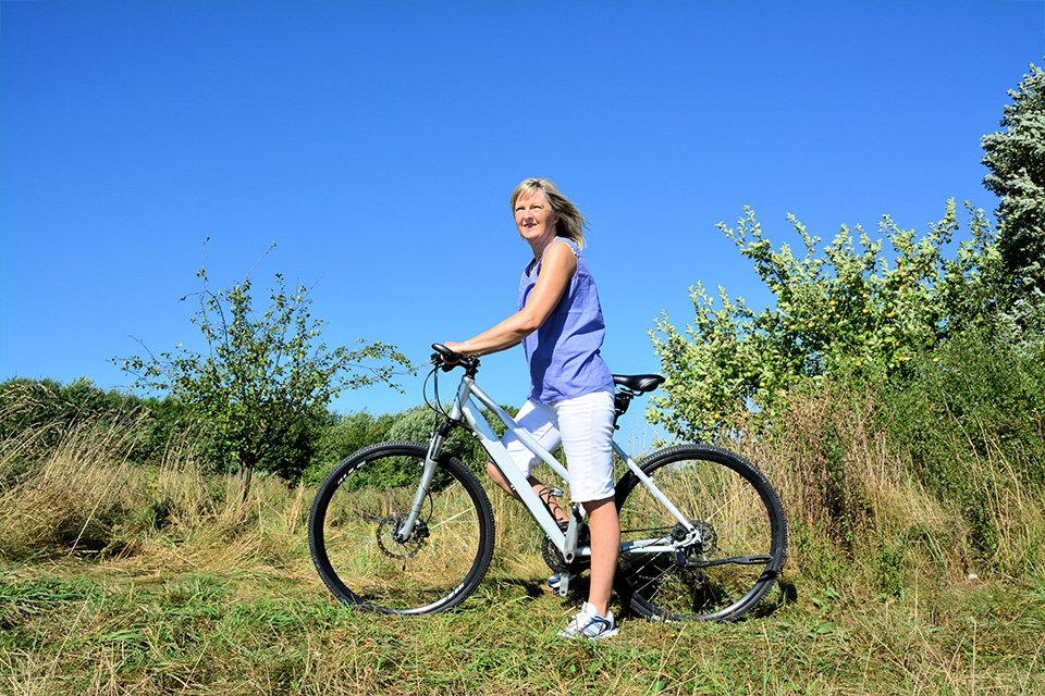 A woman on a hybrid bike on a mountain.