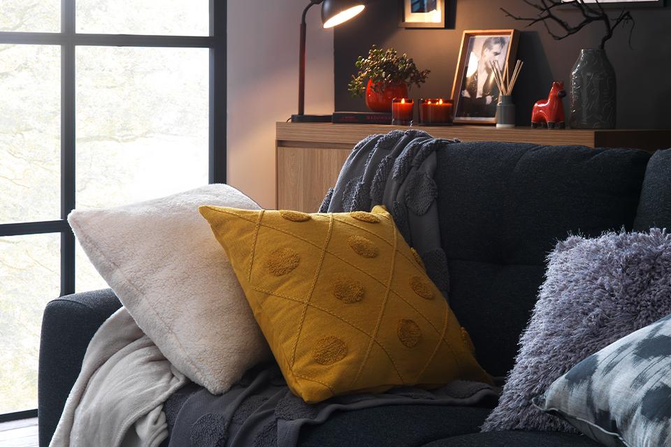 A comfy sofa topped with inviting cushions and throws.