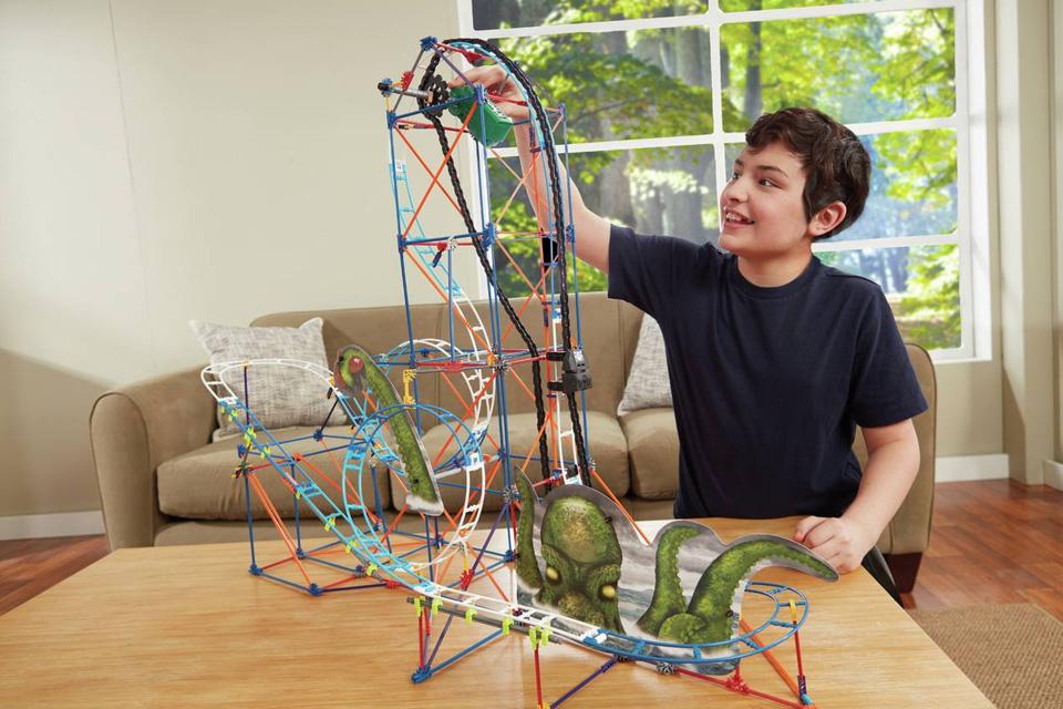 A boy admiring his completed K'NEX roller coaster.