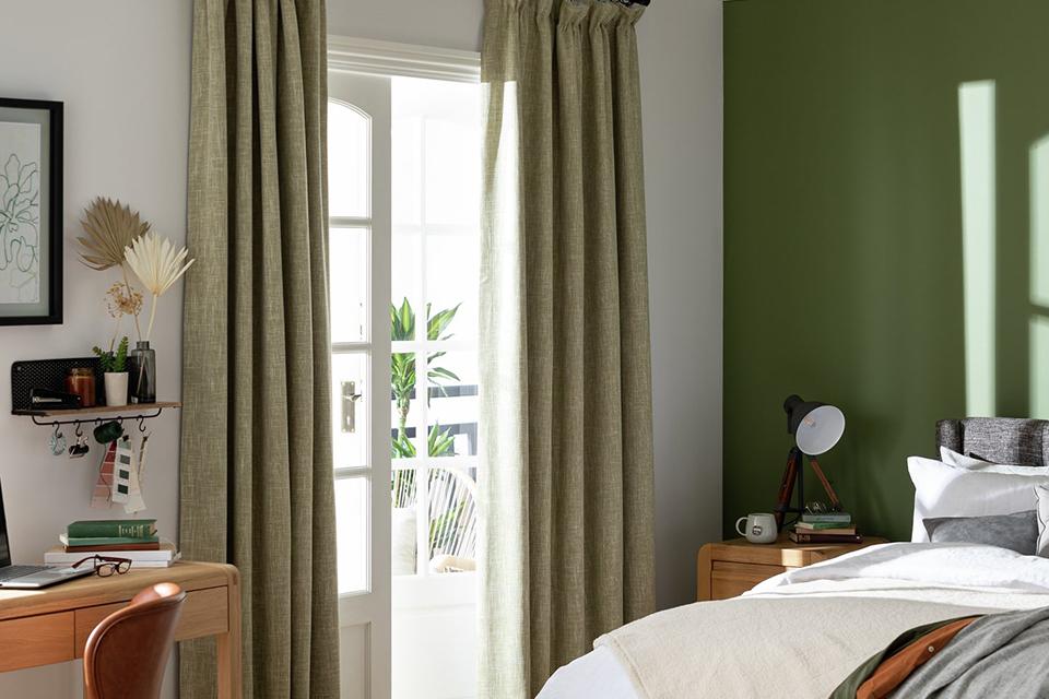 Image of a green bedroom with green blackout curtains.