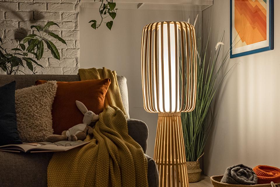 Image of a bamboo floor lamp next to a sofa.
