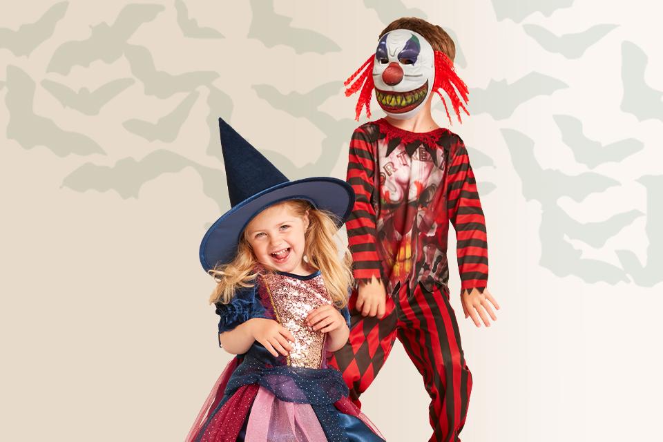 A child in a witch costume alongside a child in a clown costume.