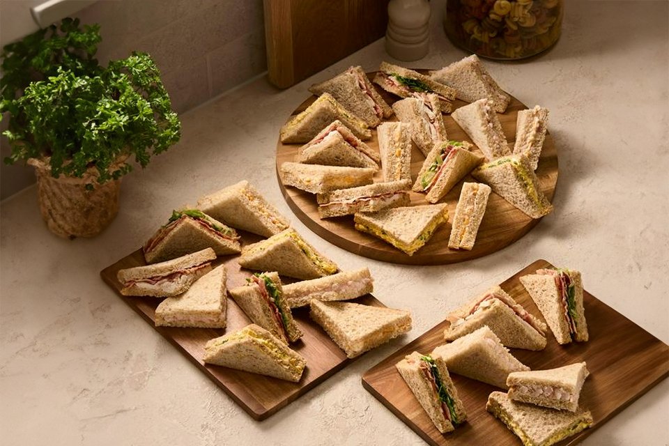 A wooden serving board with Sainsbury's large classic sandwiches.