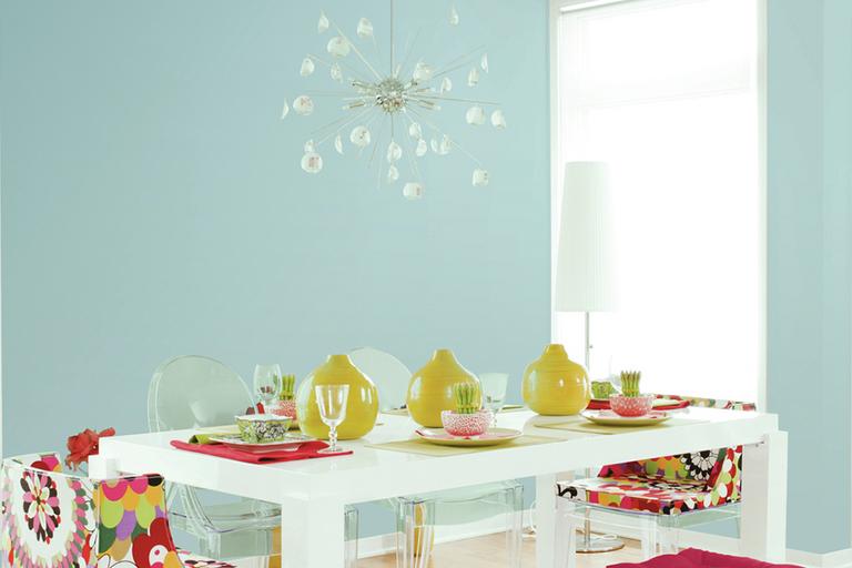 Duck egg coloured room with white table and multi-coloured furnishings.