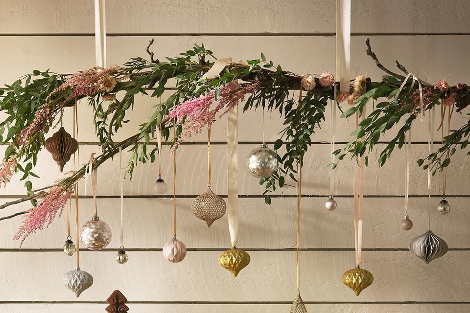 Image of a hanging branch with foliage and baubles dangling from it.