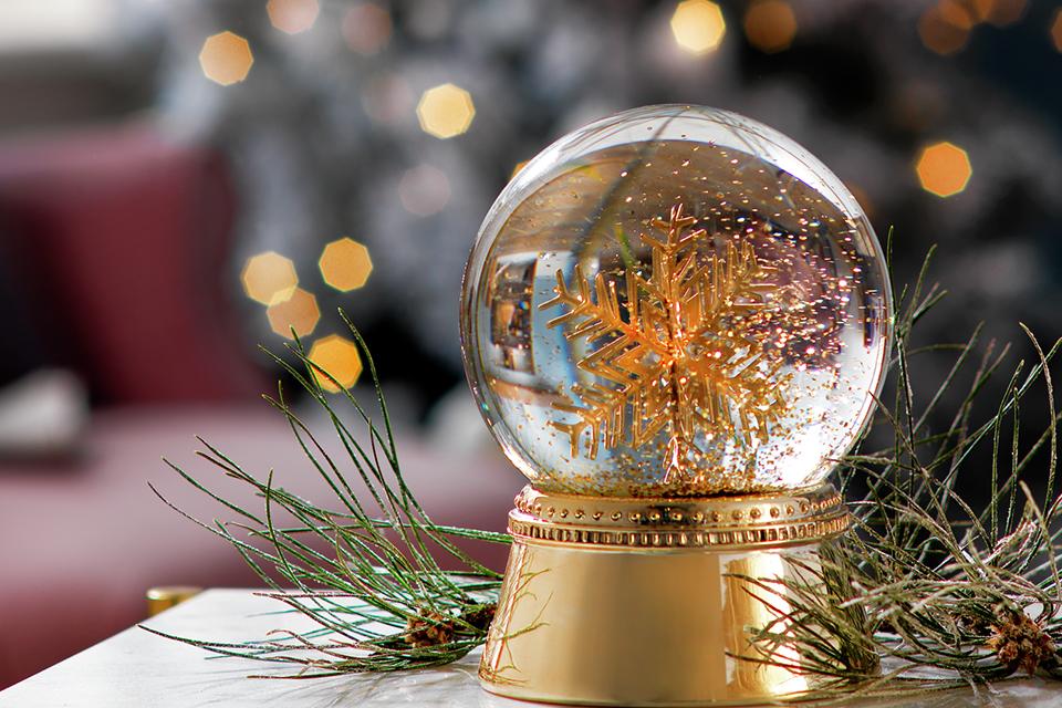 Image of a gold snow globe with a gold snowflake inside.