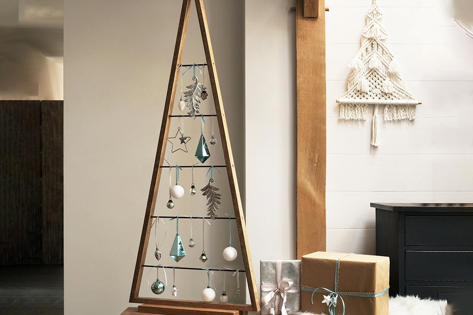 Image of a wooden Christmas tree with baubles hanging from it.