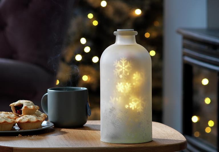Image of a snowflake projection jar on a coffee table.