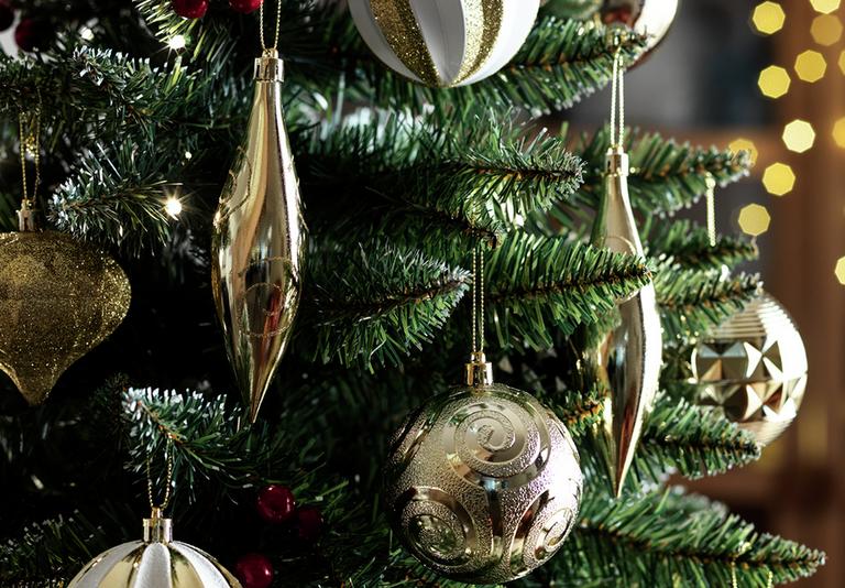 Image of gold and white baubles hanging on a tree.