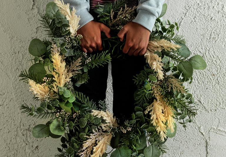 Image of a person holding a festive wreath