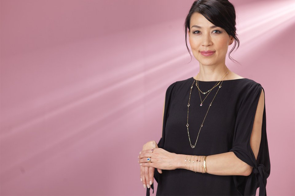 A woman in black dress wearing a Revere sterling silver cubic zirconia layer necklace.