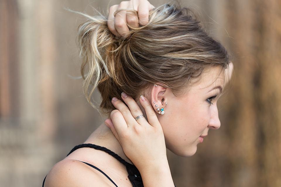 Side angle of a woman showing her ear piercings.