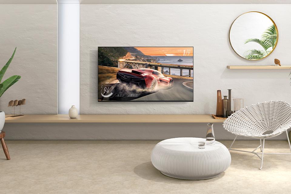 A Panasonic HX580 television is installed on a living room wall, alongside potted plants.
