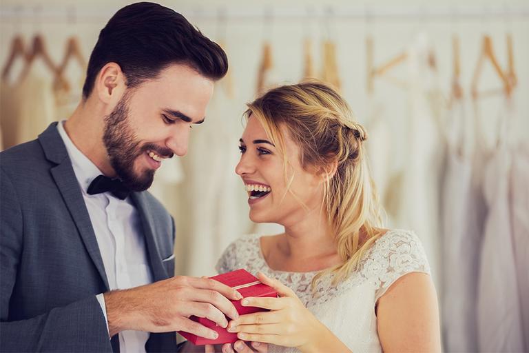A bride and groom opening a gift box together.