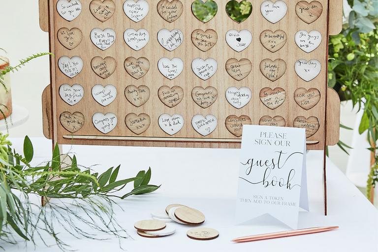 A wooden wedding guest book for everyone to write their wishes on.