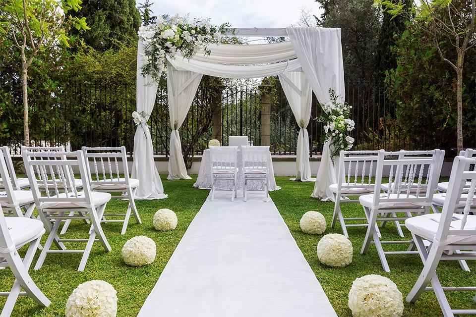 A beautiful garden wedding set-up with white aisle and decorations.