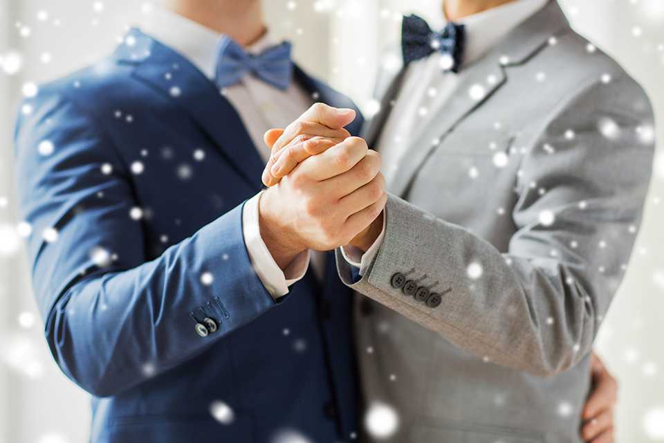 A couple holding hands and dancing on their wedding day.