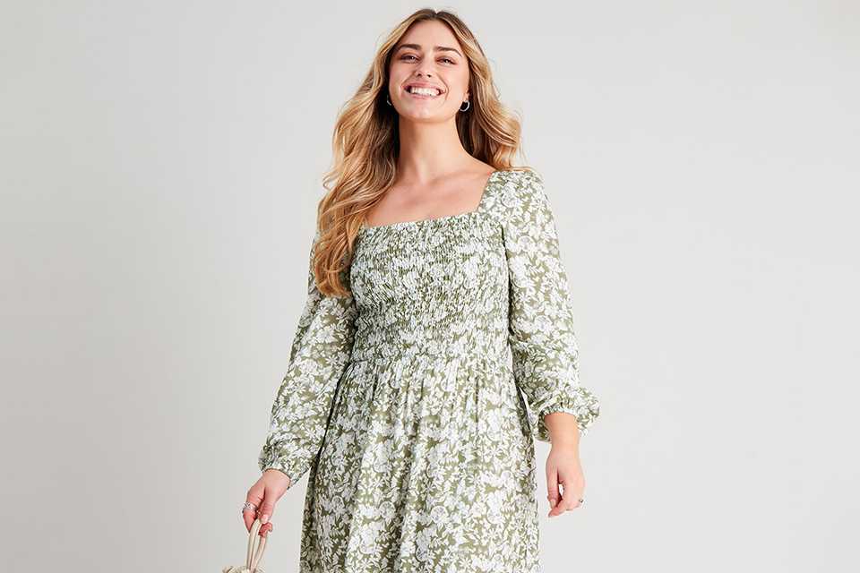 A pretty girl in a white dress with pastel green floral design.