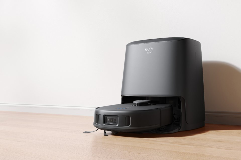 A eufy robot vacuum placed on a wooden floor.